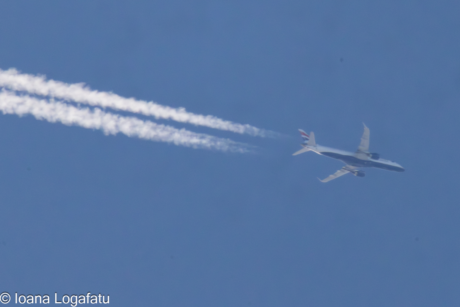 High above, an airplane leaves a vapor trail